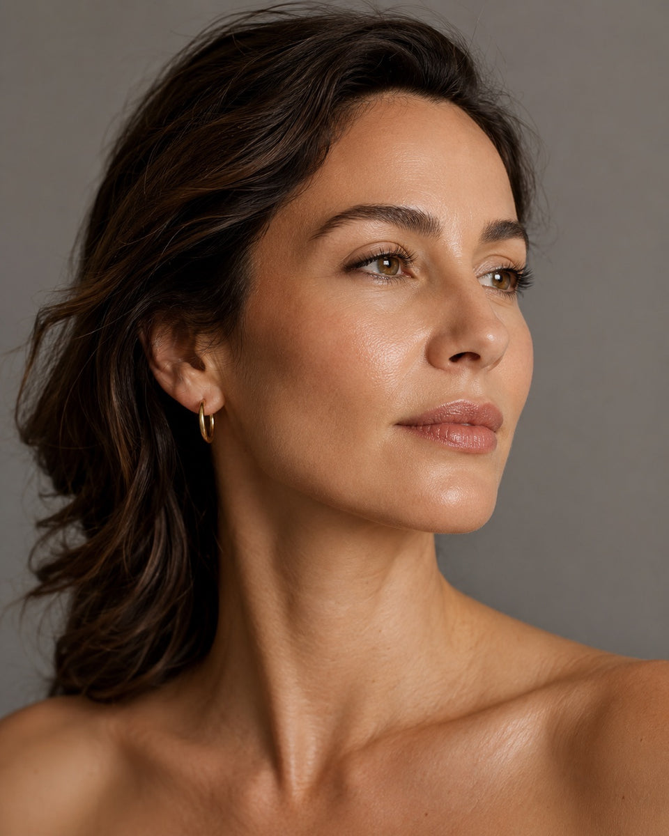 Portret van een vrouw in driekwartprofiel tegen een neutraalgrijze achtergrond