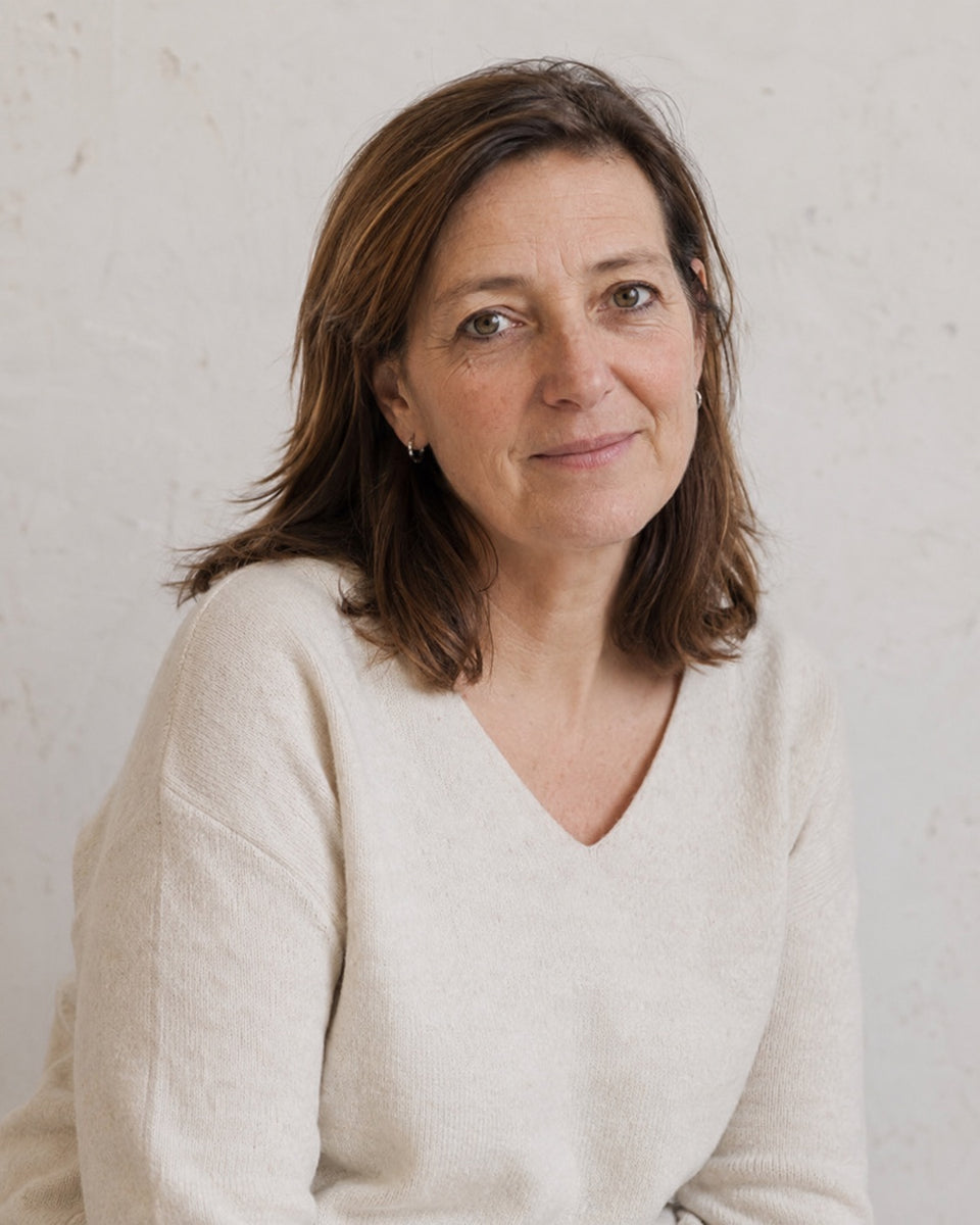Portret van een vrouw tegen een warme, lichte achtergrond