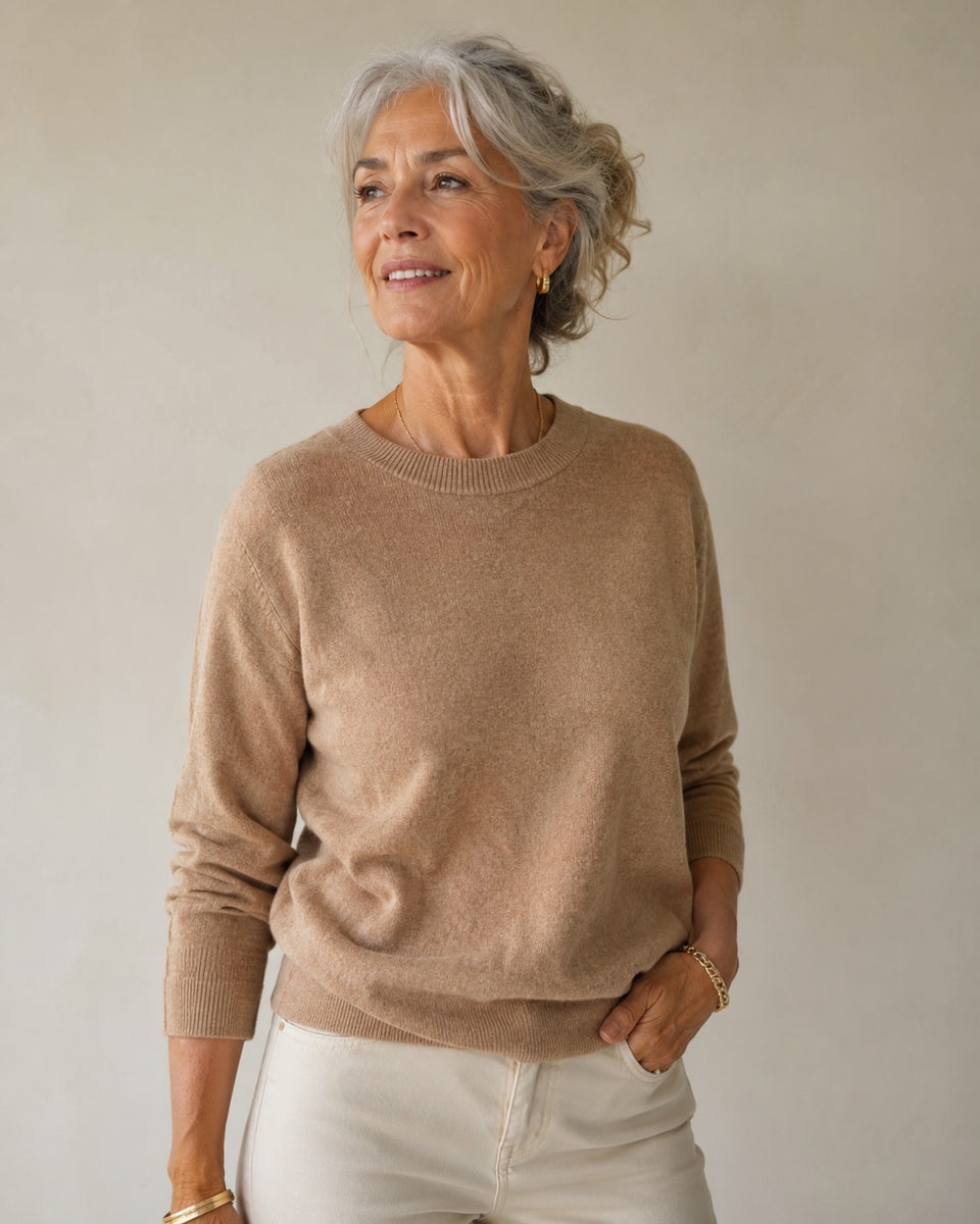 Portret van een vrouw met grijs haar tegen een warme lichte achtergrond